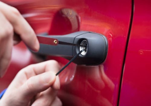 Close-up Of A Human Hand Opening Red Car's Door With Lockpicker